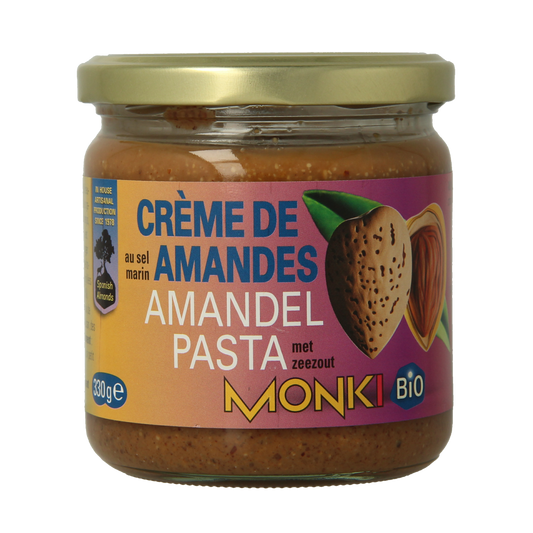 Organic almond butter with salt from Monki, 330 grams, spread on bread, showing creamy almond paste with salt crystals.