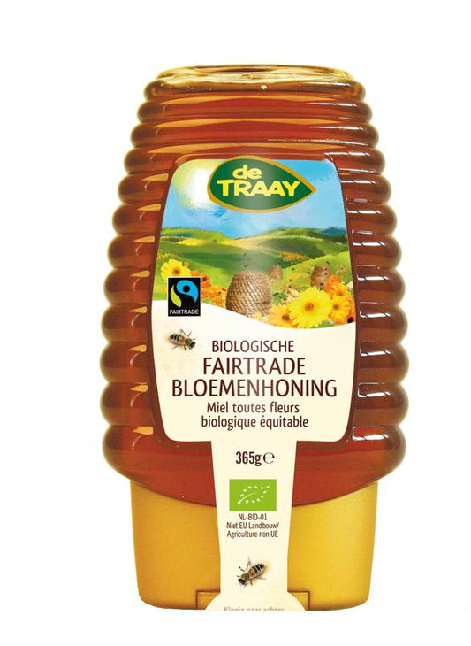 de Traay Fairtrade organic flower honey in a 365g squeezable plastic bottle with a yellow cap